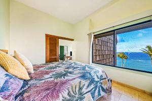 a bedroom with a bed with a view of the ocean at Penthouse Condo with Panoramic Ocean Views in Princeville