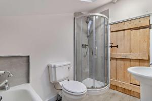 a bathroom with a shower and a toilet and a sink at Hawker Cottage in Lavenham +10 photos