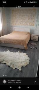 a bedroom with a bed and a rug on the floor at Guest House StarSky in Karakol