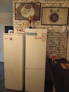 two refrigerators in a kitchen with a brick wall at Guest House StarSky in Karakol