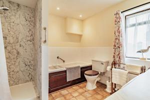 un bagno con vasca, WC e doccia di The White Horse Cottage a Saint James Altre 18 foto