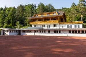 a large white building with a large parking lot at Vellach Lodge in Sittersdorf