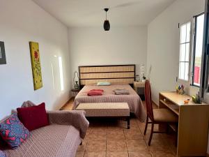 a bedroom with two beds and a table and a couch at Finca El Relincho del Alma in Tuineje +53 photos