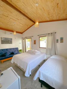 une chambre avec deux lits et un canapé bleu dans l'établissement Vila das Carnaúbas | 2 chalés (Chalés Buriti e Atins), à Barreirinhas