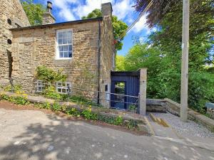 Bankside Cottage في هالتويسل: مبنى حجري قديم بباب ازرق