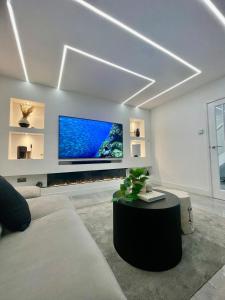 ein Wohnzimmer mit einem Sofa und einem Fernseher an der Wand in der Unterkunft Modern House with Garden and Parking in Cardiff