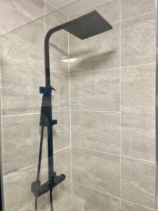 eine Dusche mit Duschkopf in einem Badezimmer in der Unterkunft Modern House with Garden and Parking in Cardiff + 34 Fotos