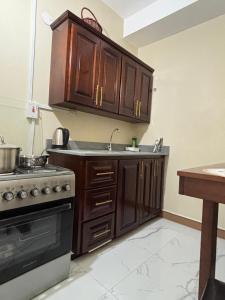 a kitchen with wooden cabinets and a sink and a stove at 360 Rokview Suites Cozy 1BR Private Suite in Kupuis