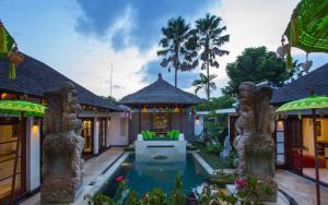 an exterior view of a house with a swimming pool at Villa Zamaya Sanur in Sanur