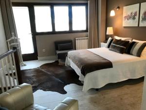 a bedroom with a large bed and a chair at Apartamentos El Hospital de Villahormes in Villahormes