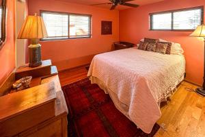 a bedroom with a bed and two windows at Hummingbird Hideaway in Tucson