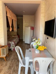 a living room with a table and chairs and a television at Casa em frente a praia - Ilha dos Frades in Salvador