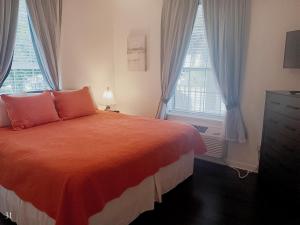 a bedroom with a bed and two windows at The Cozy Inn in Saint Augustine