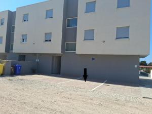 a large white building with a parking lot at Apartman Zeljka in Pula
