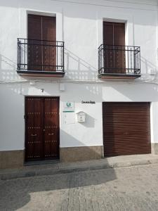 two doors on the side of a white building at Casa de los Abuelos in Cardeña