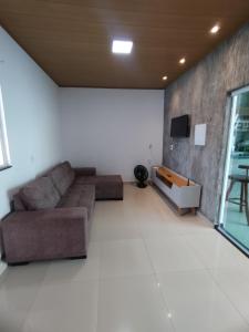 salon z kanapą i telewizorem w obiekcie Casa Barra de são Miguel w mieście Barra de São Miguel