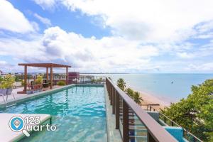 a swimming pool with a view of the beach at Get Sense By 123Quarto Hospedagem in Tambaú