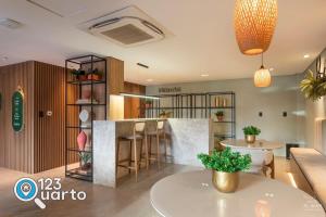 a kitchen with a bar with stools at Get Sense By 123Quarto Hospedagem in Tambaú