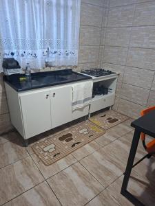 a kitchen with a sink and a stove at Apartamento para família in Guarapuava