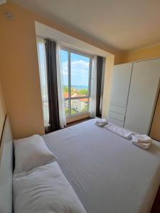 a bedroom with a large bed with a large window at Deymar Apartments VIEW in Vidin