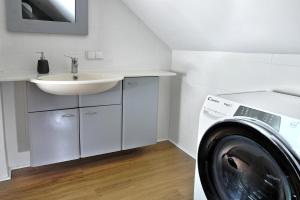 a bathroom with a washing machine and a sink at Agrosfera dom relaksacyjny in Zwierzewo