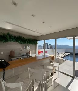 uma cozinha e sala de jantar com vista para o oceano em Suíte em flat no Gonzaga Stay Helbor em Santos