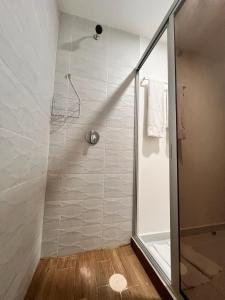 カンクンにあるDepartamento con Vistas y Albercaのガラスドア付きのシャワー付きのバスルーム