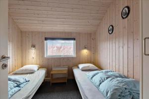 two twin beds in a room with a window at M187-Vaeggerlose-Baeverstien-48 in Marielyst