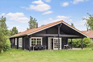 a log cabin with a table and chairs in a field at M130-Vaeggerlose-Marielyst-Strandpark-125 in Marielyst
