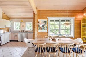 a kitchen with a large wooden table and chairs at M130-Vaeggerlose-Marielyst-Strandpark-125 in Marielyst +14 photos