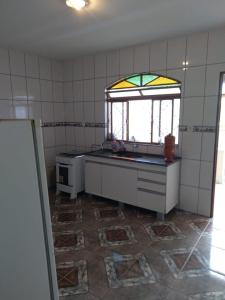 eine Küche mit Spüle und Fenster in der Unterkunft Recanto da Celinha - Casa em Tiradentes in Tiradentes
