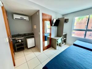 a room with a bedroom with a bed and a desk at hotel Green Sunset 406 in João Pessoa