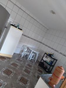 eine Küche mit zwei weißen Stühlen und einem Fliesenboden in der Unterkunft Recanto da Celinha - Casa em Tiradentes in Tiradentes + 5 Fotos