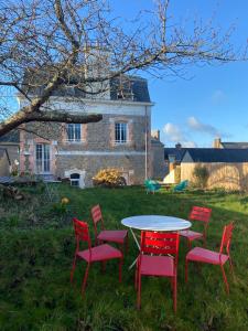 une table et des chaises devant une maison dans l'établissement ancienne poste de Saint coulomb, à Saint-Coulomb