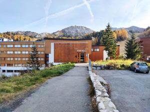 a building with a car parked in a parking lot at Résidence Makalu - Studio divisible 4 personnes Plagne Centre MAE-3484 in Aime La Plagne