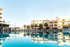 a swimming pool with chairs and buildings in the background at Topaz Hotel in St Paul's Bay