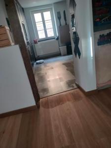 a living room with a wooden floor and a refrigerator at Les 5 Hiboux in Oberbronn