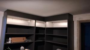 a black cabinet with lights in a room at Les 5 Hiboux in Oberbronn