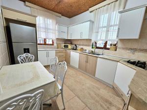 a kitchen with white cabinets and a table and chairs at Burcu Guest Home in Çağlayan