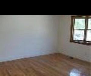 an empty room with a window and a wooden floor at Franklin street allston in Boston