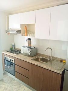 une cuisine avec un évier et une cuisinière dans l'établissement Departamento La serena, à La Serena