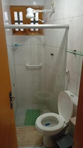 Un baño con inodoro y ducha con puerta de cristal. en Casa em Porto de Galinhas - PRIVÊ DAS ONDAS, en Porto de Galinhas