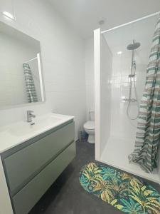a bathroom with a sink and a shower and a toilet at Les chambres du Vignoble in Pauillac