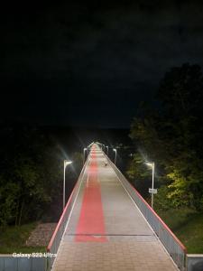 a long bridge at night with a red path at RentA Citywalk Flat in Kaunas