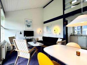 a living room with a table and chairs and a couch at M358-Vaeggerlose-Norrevang-38 in Bøtø By +6 photos