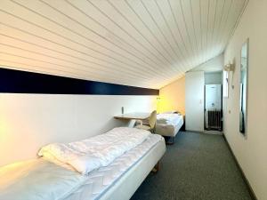 a bedroom with two beds and a desk in it at M358-Vaeggerlose-Norrevang-38 in Bøtø By