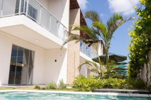 a house with a swimming pool in front of it at Zayn pousada in Barra Grande