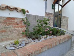 a brick retaining wall with flowers and plants at Vico Poerio 1 in Tursi