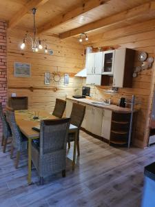 a kitchen and dining room with a table and chairs at Fajny Domek in Łukęcin