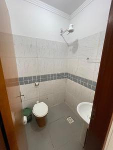 a bathroom with a toilet and a sink at Suítes Família Imperial in Uberlândia